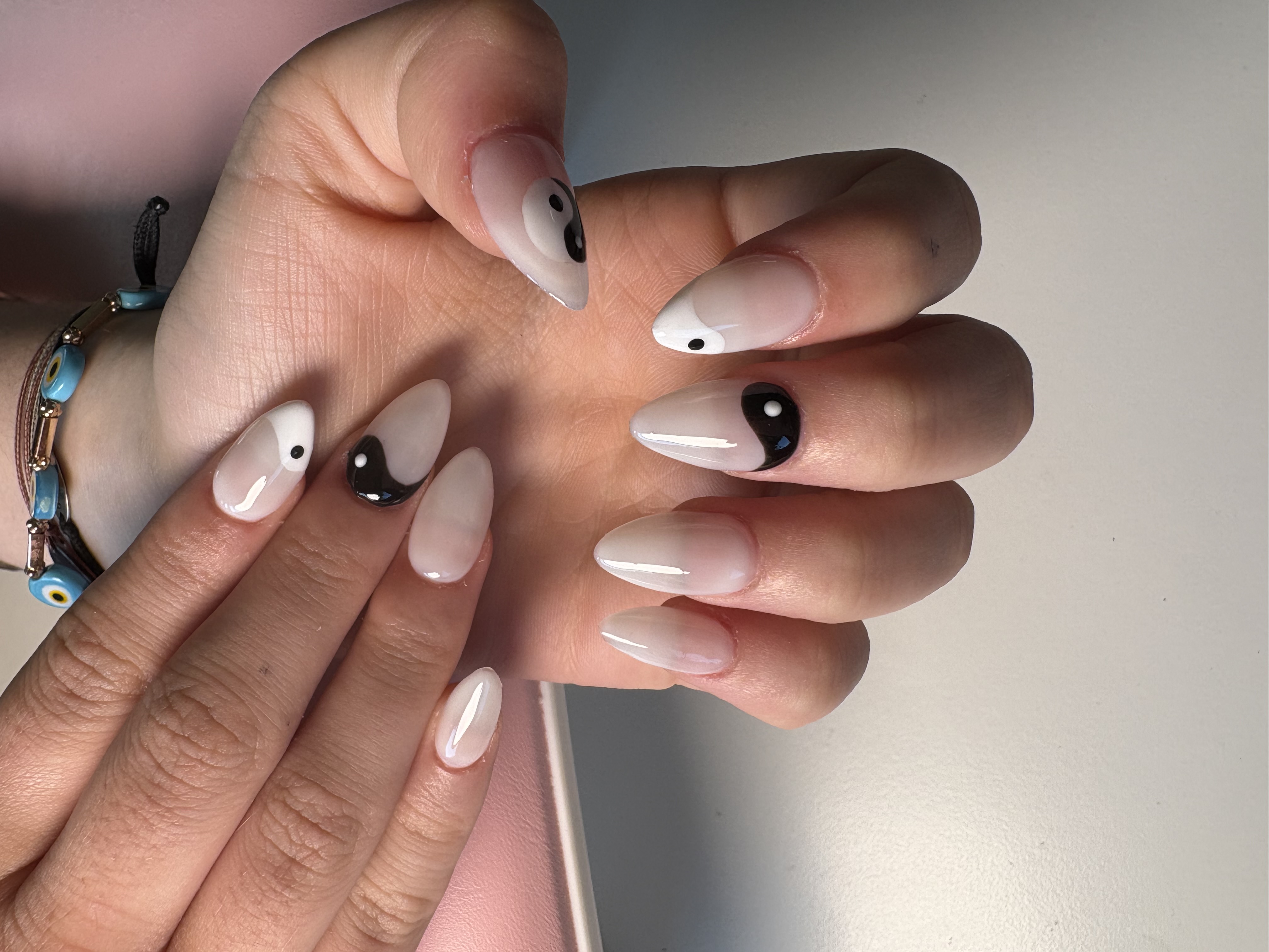 Nude ombre almond nails with black-and-white yin-yang symbol accent nails