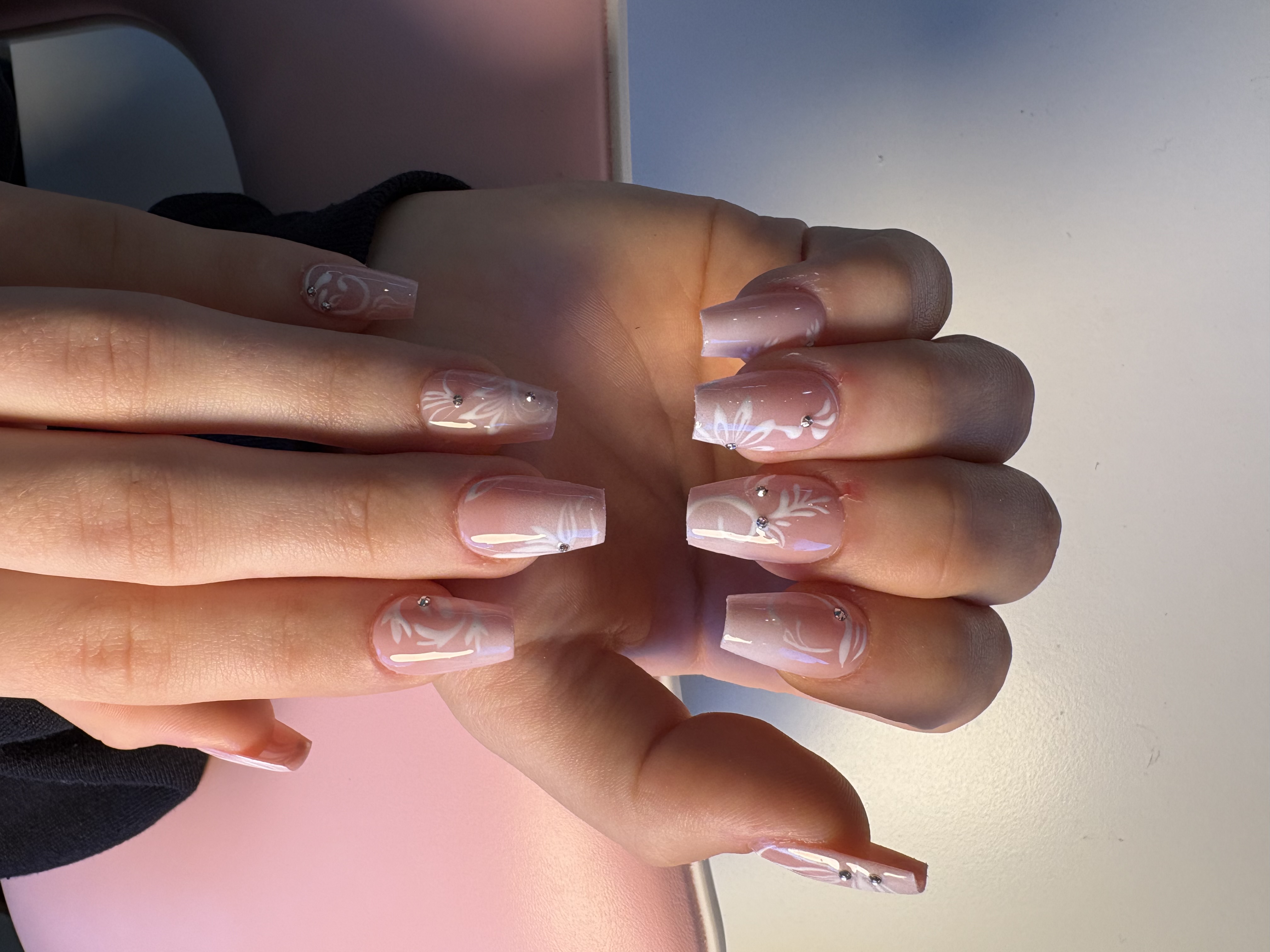 Red and nude almond nails with negative-space heart cutouts and lace-pattern accents