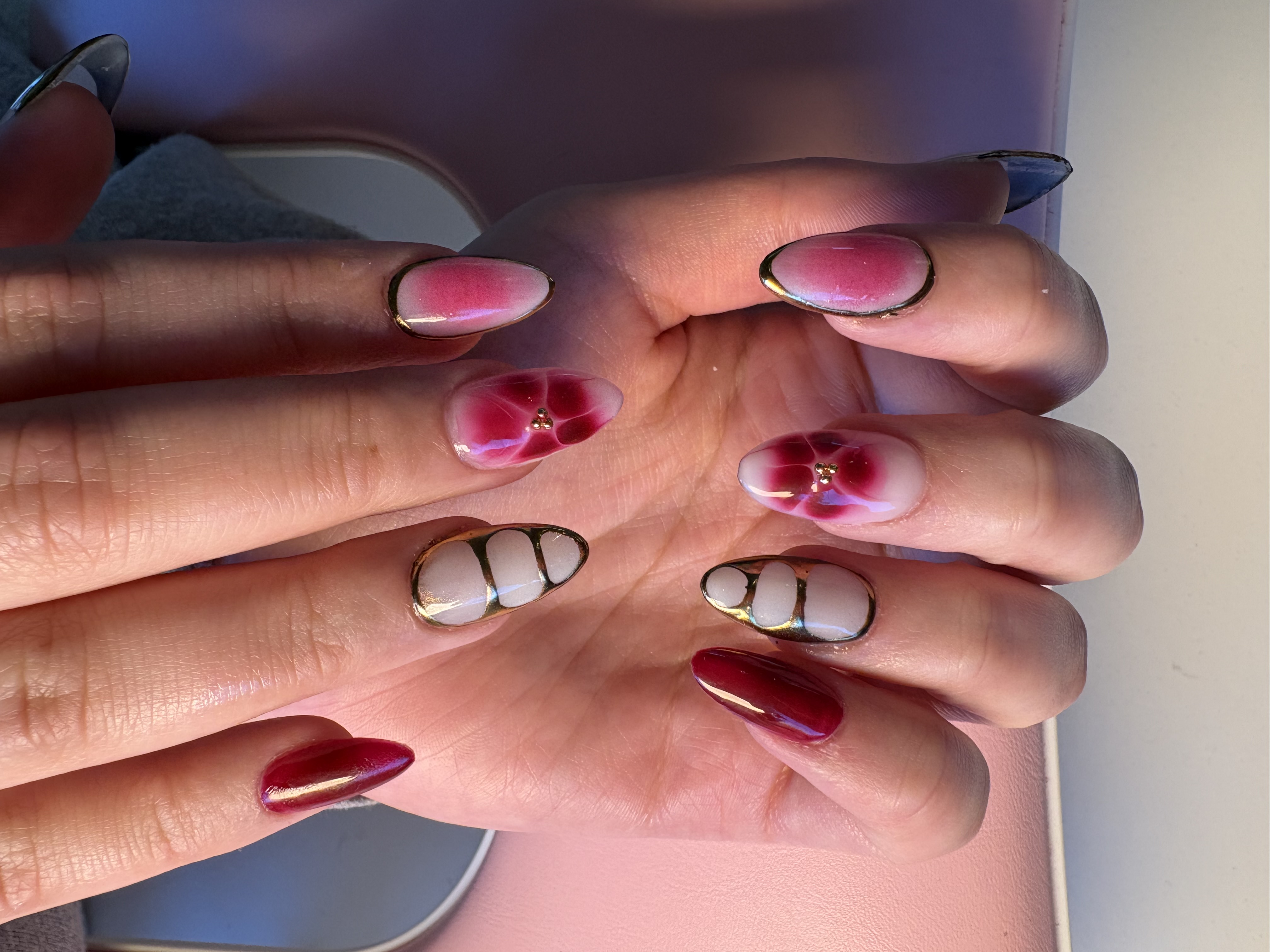 Burgundy ombre almond nails with gold chrome edges and 3D floral rhinestone art