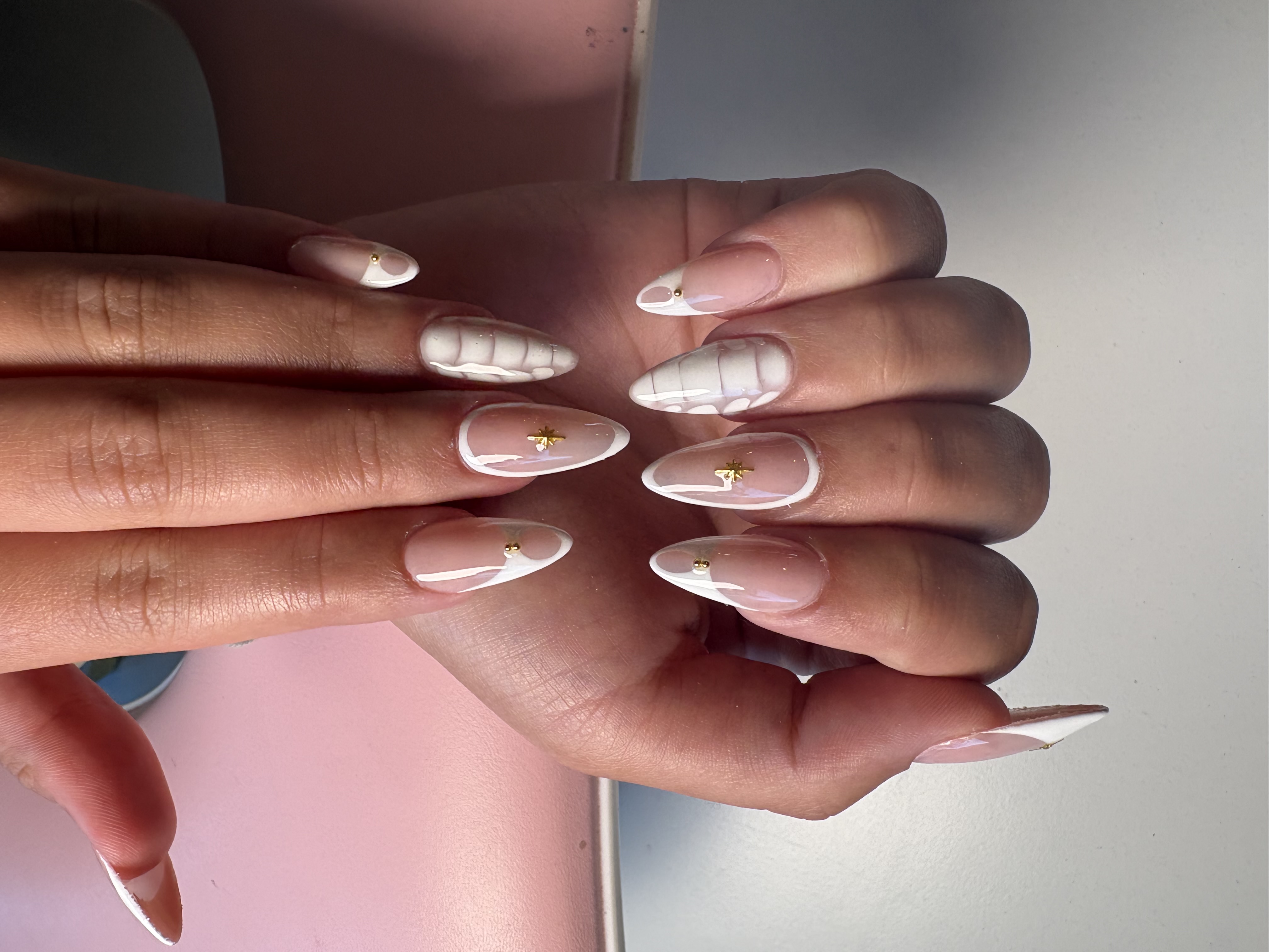 Nude almond nails with sculpted 3D white French tips and gold star rhinestone accents